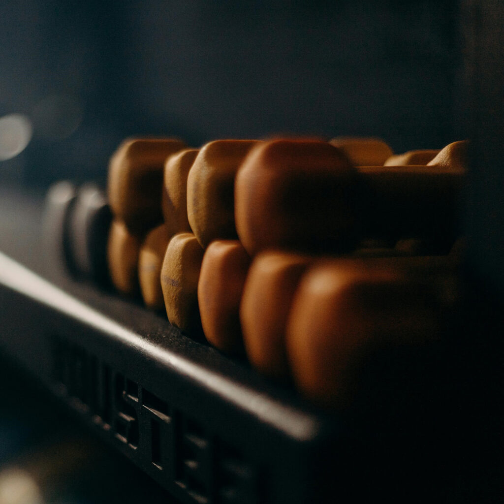 Close-up of a rack of small dumbbells in a dimly lit gym, symbolizing beginner-friendly fitness and personal trainin